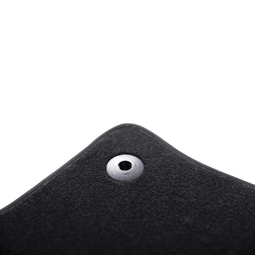 Close-up of a black textured mat with a metal eyelet on a white background