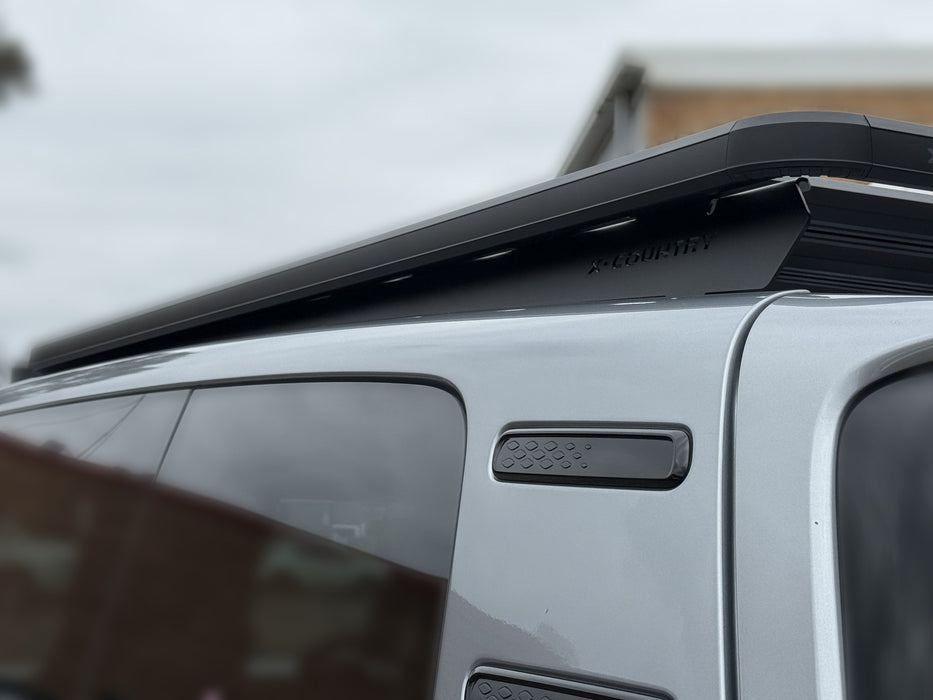 Close-up of X-Country Summit platform edge bracket and roof rail clamp on VW ID Buzz