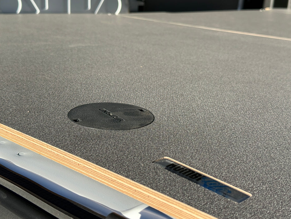 Close-up of a textured surface with a circular black object and metallic edge.