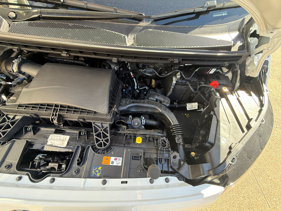 Open car hood revealing the engine compartment.