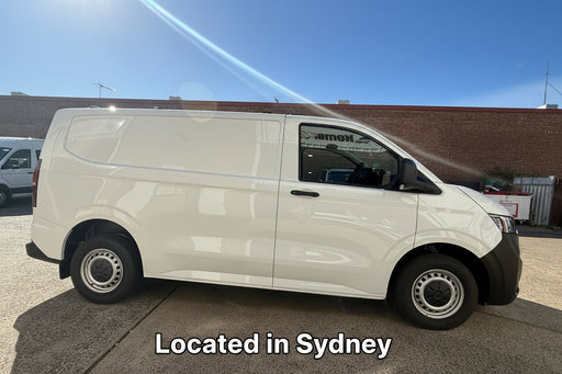 White t7 transporter van parked on a concrete surface with a clear blue sky.