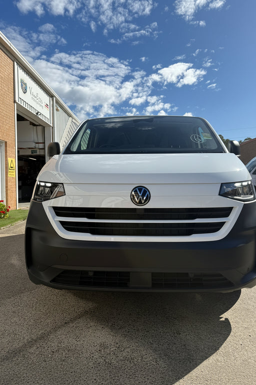 Volkswagen t7 transporter car parked on a driveway with a clear blue sky.