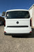 White Volkswagen t7 Transporter van parked on a concrete surface with a clear blue sky.
