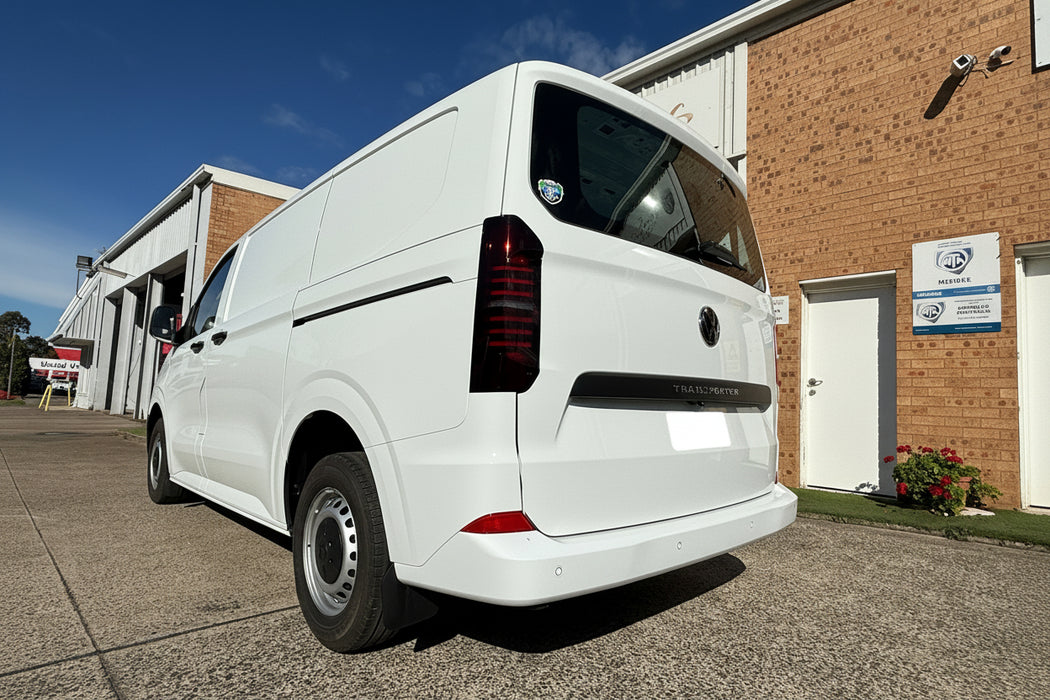 White van parked in front of a building with a blue sky.