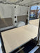 Van interior with a flatbed and open door, showing a building exterior in the background.