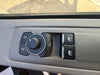 Car control panel with buttons and a knob on a gray dashboard.