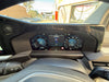 Car dashboard with digital instrument cluster showing speedometer and other metrics.