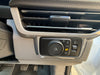 Car interior air vent and control panel with buttons and knobs.