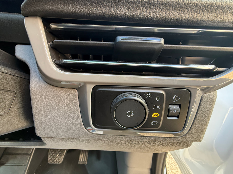 Car interior air vent and control panel with buttons and knobs.