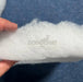 Person holding a roll of white foam with DodoMat branding.